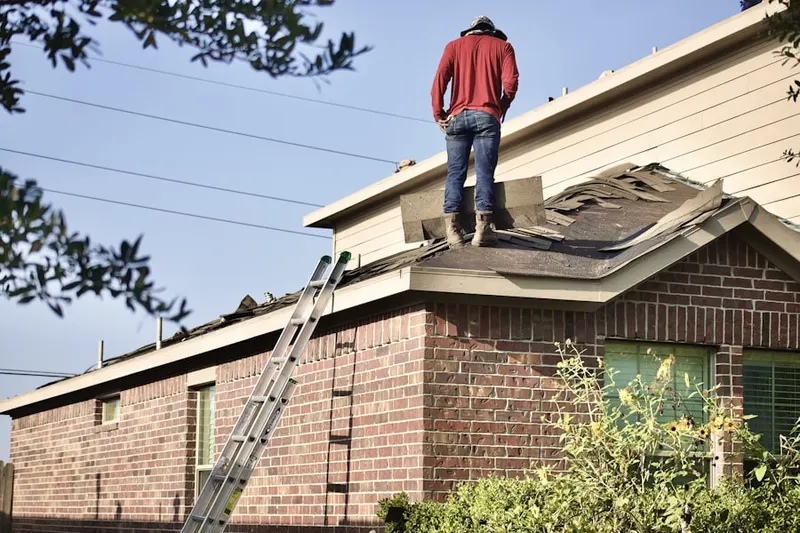 Professional roofer working on a residential roof in Penelope